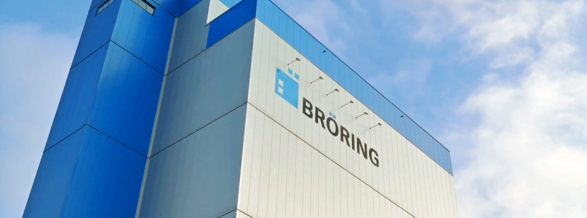 Außenansicht des BRÖRING Produktionswerks in Löningen vor blauem Himmel. BRÖRING Logo im Fokus.