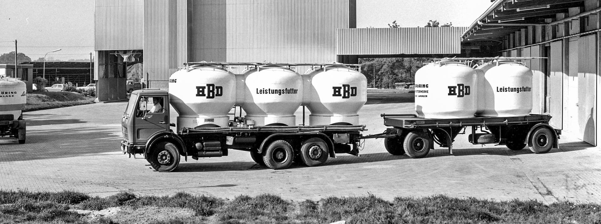 Historische Aufnahme eines alten Silo-LKWs mit Anhänger und Aufschrift HBD Leistungsfutter vor dem Produktionswerk in Löningen